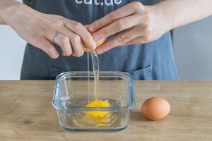 Eier in eine Schüssel schlagen