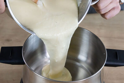 Käse in den Fonduetopf geben
