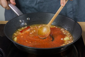 passierte Tomaten in Pfanne geben und rühren