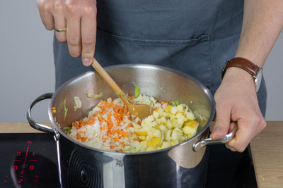 Möhren, Zwiebel und Knoblauch in den Topf geben und anschwitzen.