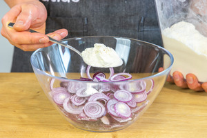 Zwiebeln und Mehl in Schüssel geben
