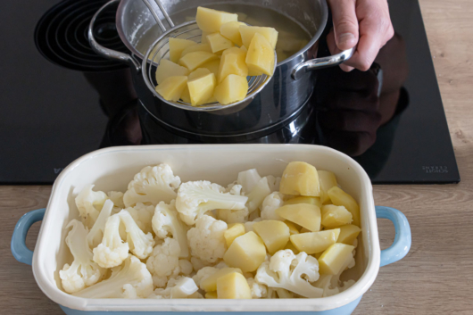 Kartoffeln und Blumenkohl in eine Auflaufform geben