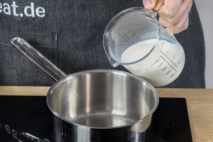 Milch in den Topf gießen