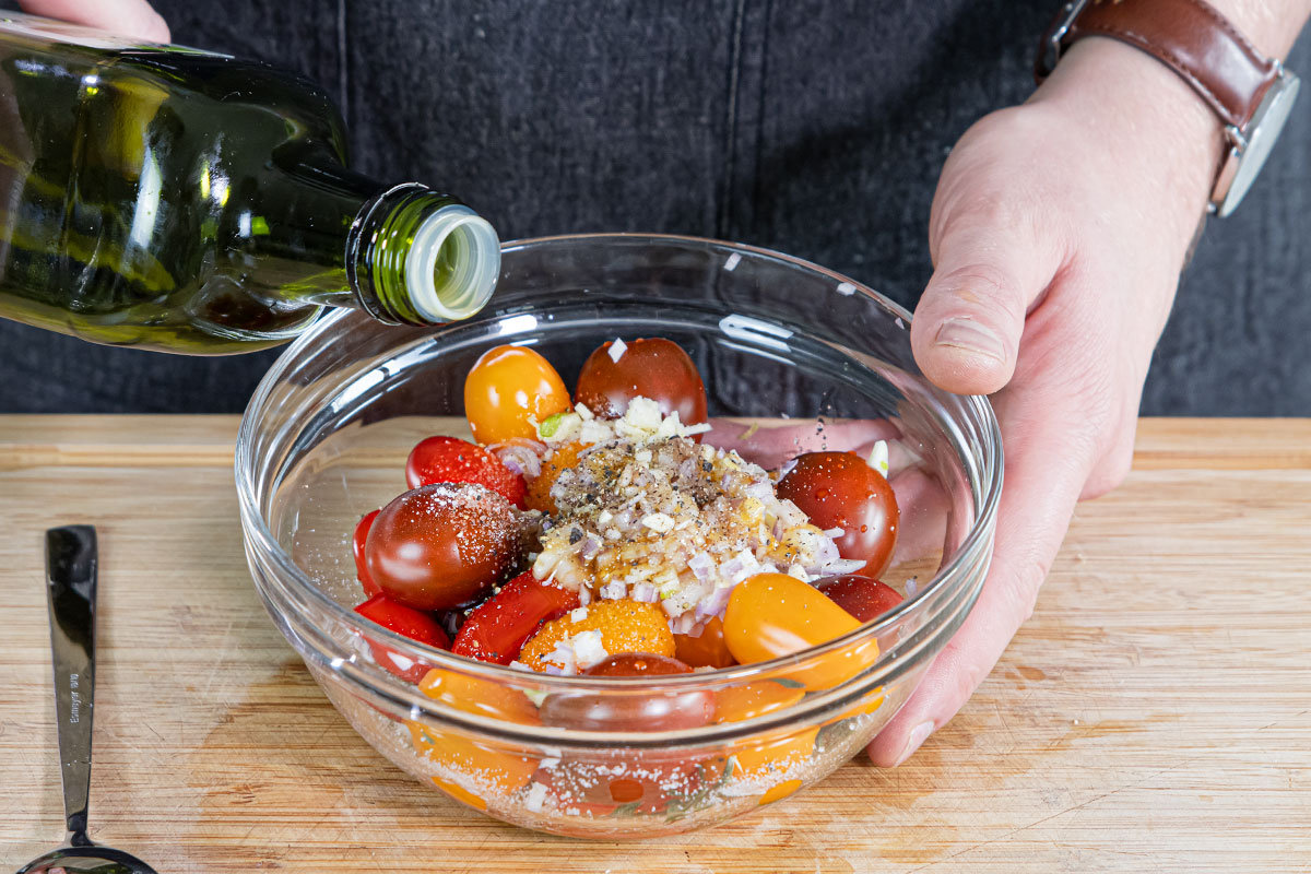 Tomaten und Zwiebeln mit Öl, Salz und Pfeffer marinieren
