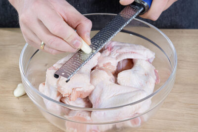Knoblauch zu den Hähnchenflügeln reiben