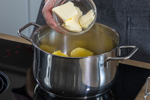 Butter zu den noch warmen Kartoffeln hinzugeben