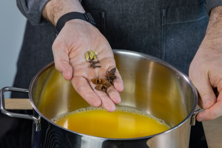 Gewürze zum Orangensaft geben