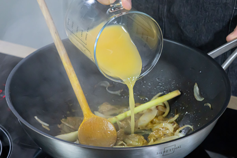 Orangensaft in den Wok gießen