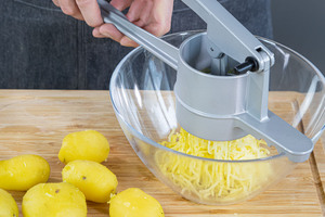 Kartoffeln durch die Kartoffelpresse drücken
