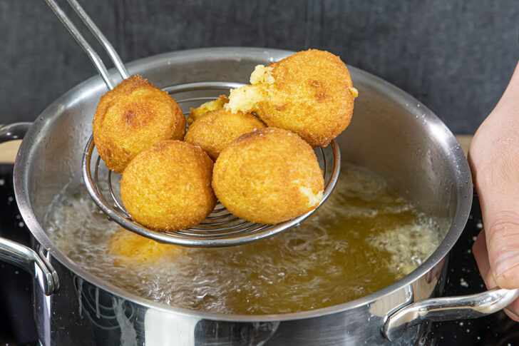 Kartoffelbällchen aus dem Öl nehmen