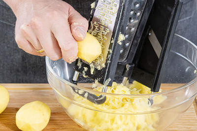 Kartoffeln schälen und fein reiben