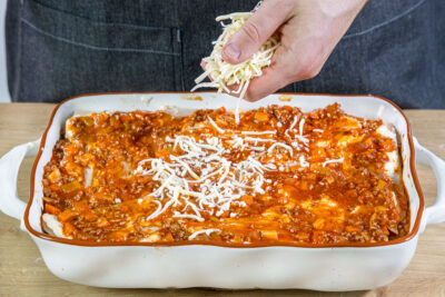 Käse über Klassische Lasagne mit Hackfleisch streuen