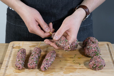 Das Hackfleisch um einen Holzspieß zu den Köfte formen.