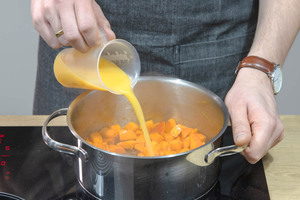Kürbis mit Orangensaft ablöschen.