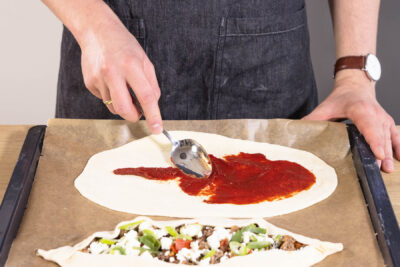 Teig mit Tomatenmark bestreichen