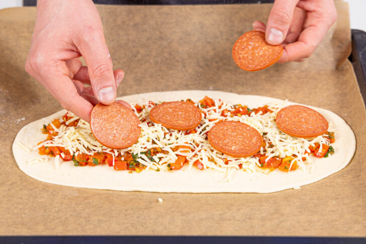 Pide mit Tomatensoße, Käse und Sucuk belegen