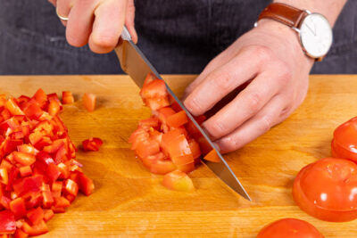 Tomaten und Paprika in Würfel schneiden