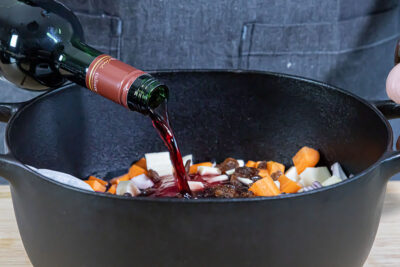 Rotwein zum Fleisch geben und den Sauerbraten marinieren