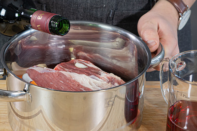 Rotwein und Essig zum Fleisch geben