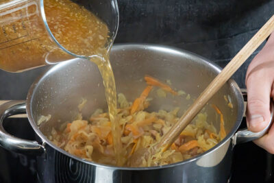 Gemüsebrühe zum Sauerkraut mit Kassler geben