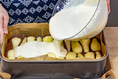 Schmandcreme auf dem Kuchen verteilen