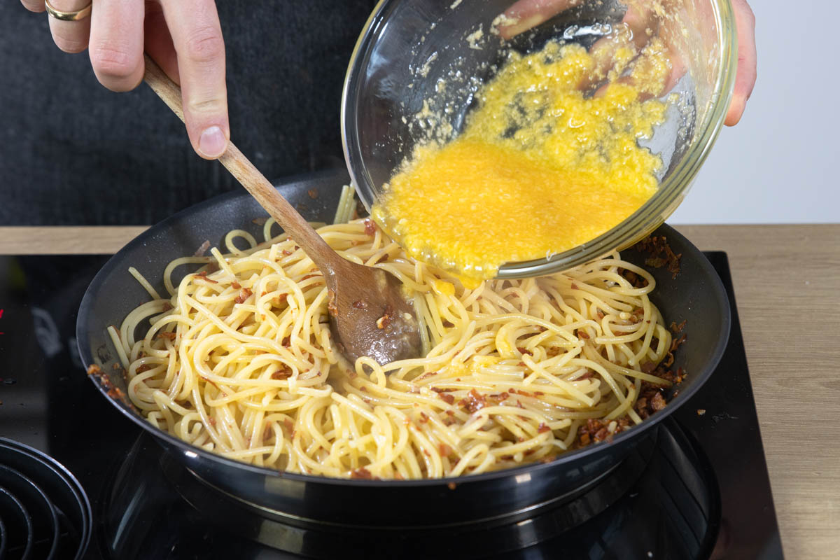 Das Käse-Ei-Gemisch zu den Spaghetti dazugeben.