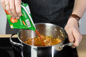 Für den Tomatenreis wie beim Grieche passierte Tomaten zu dem Reis geben.