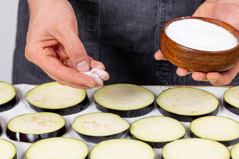 Aubergine in Scheiben schneiden und von beiden Seiten salzen.