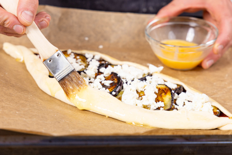 vegetarische Pide mit Aubergine Rand mit Ei-Milch-Gemisch einstreichen