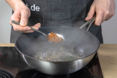 Für das gelbe Thai Curry die gelbe Currypaste dazugeben.