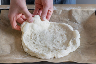 Pizzateig mit Biga in die gewünschte Form ziehen