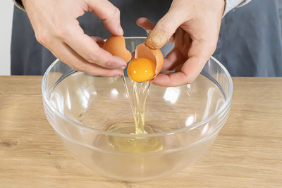 Eier in eine Schüssel schlagen