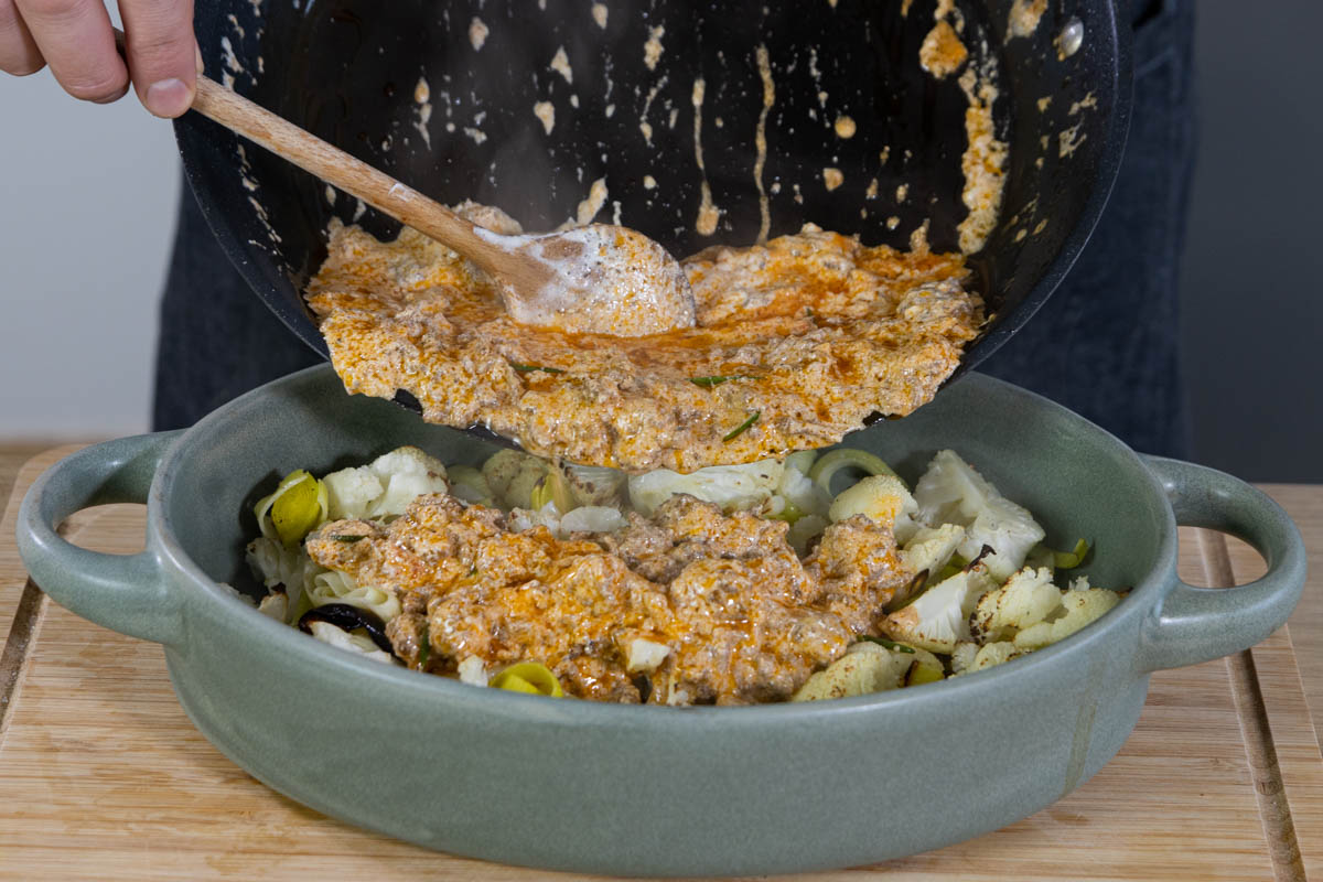 Die Soße für den Auflauf mit Hackfleisch dazugeben.