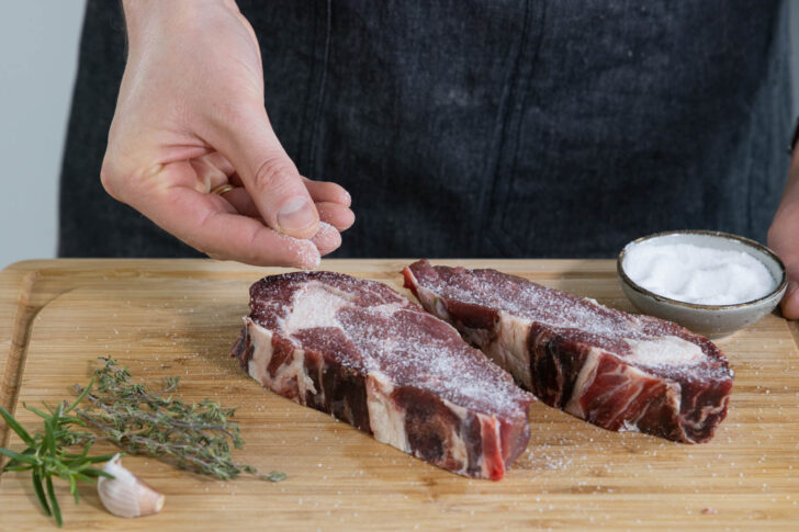 Die Steaks salzen.