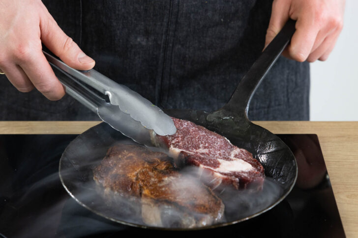 Die Steaks wenden.