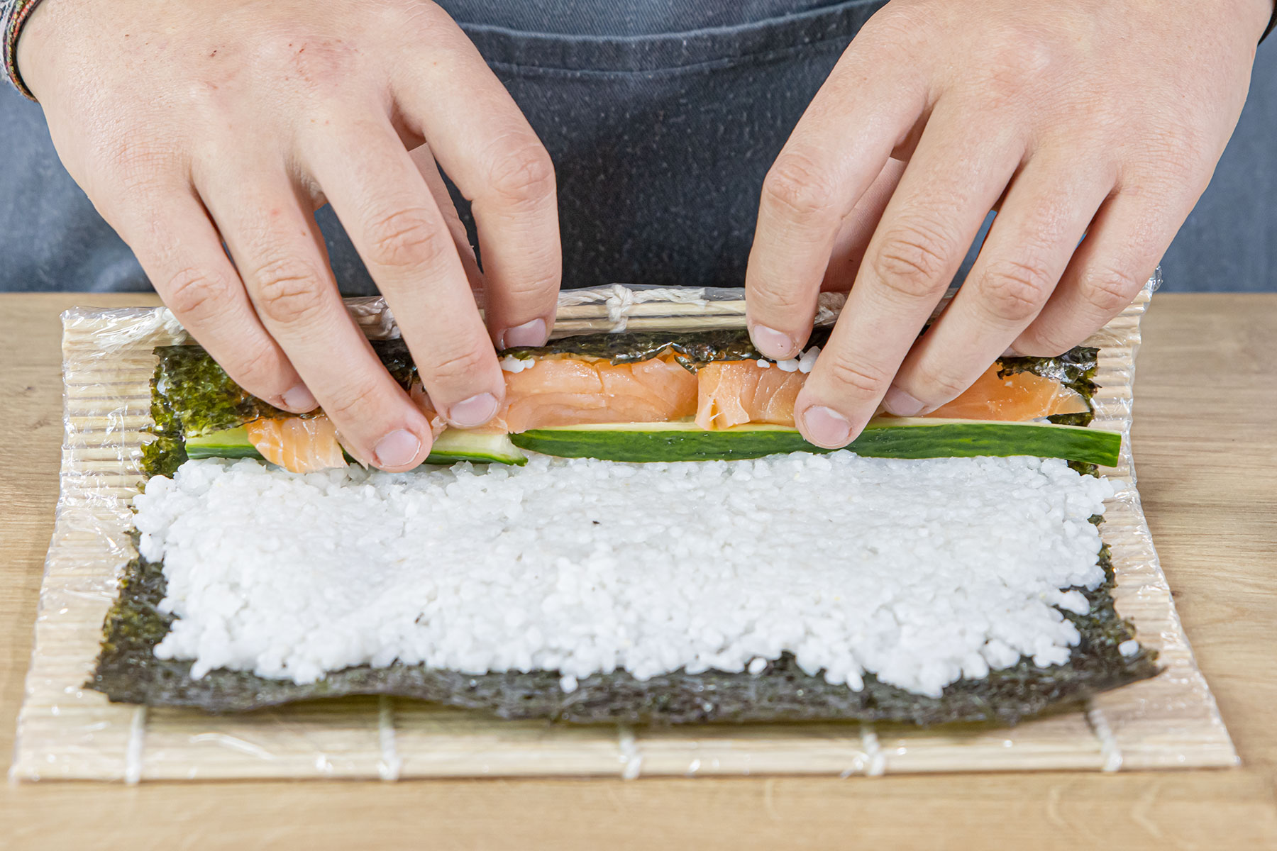 Sushi mit Füllung zusammenrollen