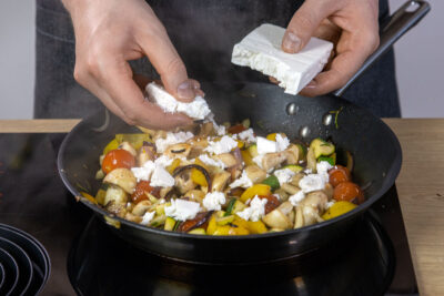 Feta in die Gemüsepfanne bröseln