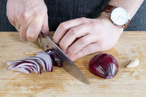 Zwiebeln und Knoblauch in Streifen schneiden