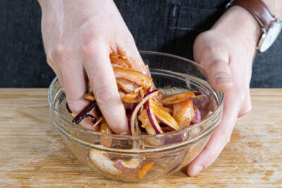 Hähnchen und Zwiebeln it der Marinade vermischen