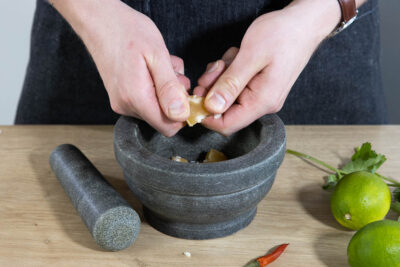 Für das grüne Nuoc Cham Palmzucker in den Mörser bröseln.