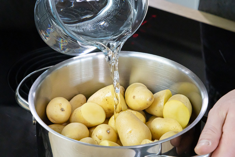 Kartoffeln mit Wasser in den Topf geben
