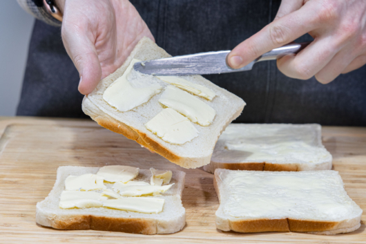Butter auf den Toast geben