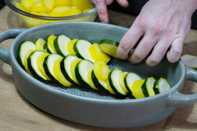 Zucchini und Kartoffel in die Form schichten