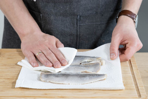 Für den Matjes nach Hausfrauenart den Fisch abtupfen.