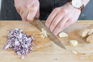 Zwiebeln und Knoblauch in Würfel schneiden