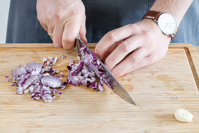 Zwiebeln und Knoblauch in feine Würfel schneiden