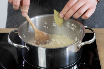 Lorbeerblatt zum Risotto mit Milchreis hinzufügen.