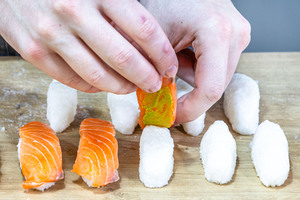 Lachs auf den Reis geben