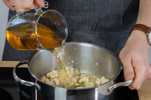Gemüsebrühe zu den Cashews gießen