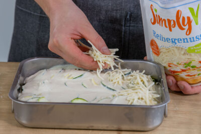 Käse über den veganen Kartoffelauflauf geben
